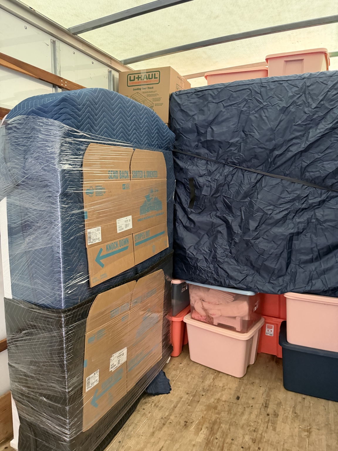 Blanket-wrapped furniture secured inside a moving trailer