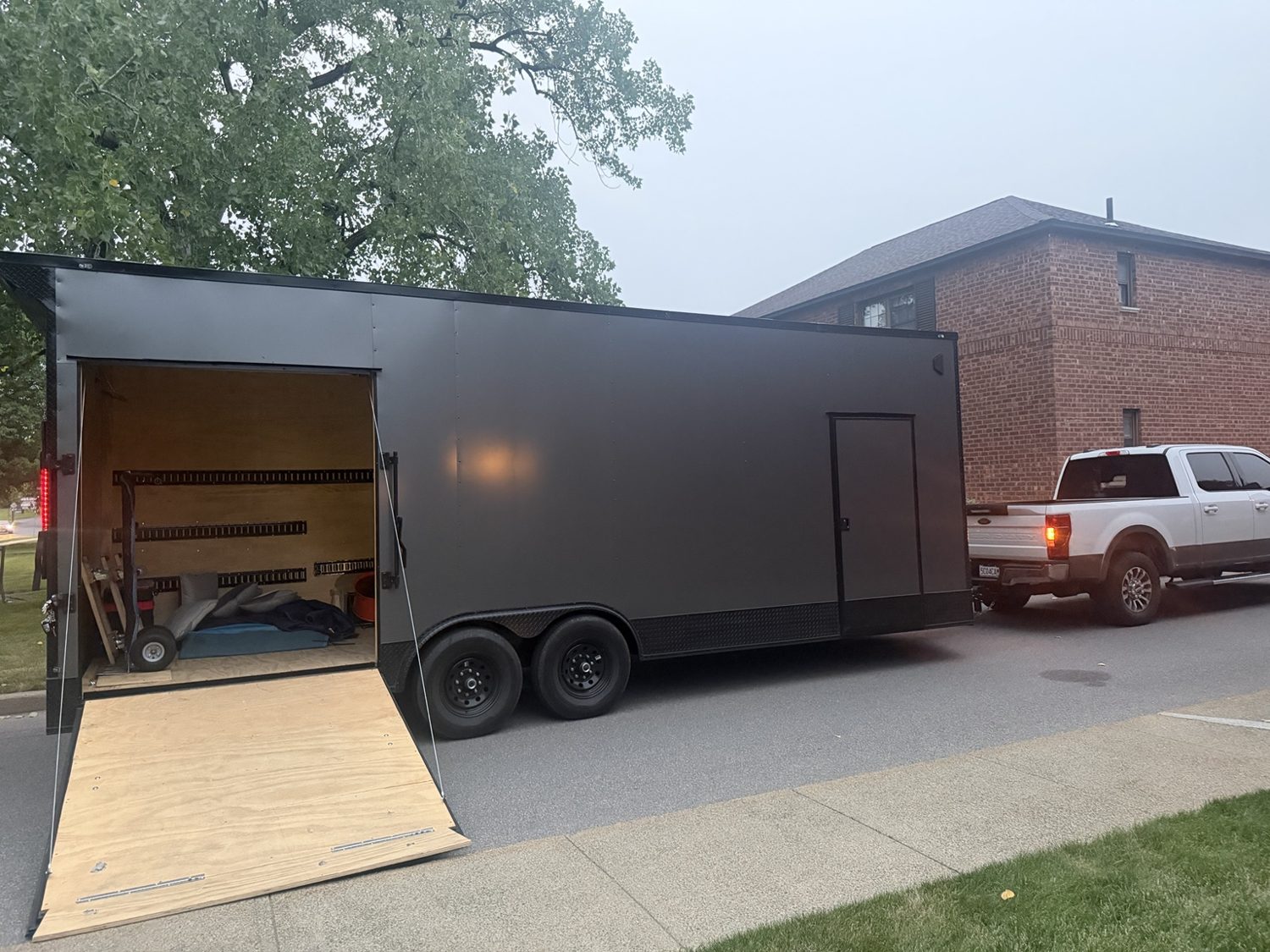 Pure Muscle Moving enclosed trailer with loading ramp and work truck